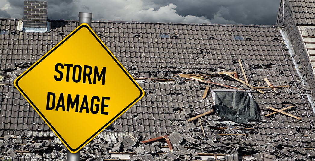 Damaged Roof and Storm Damage Sign
